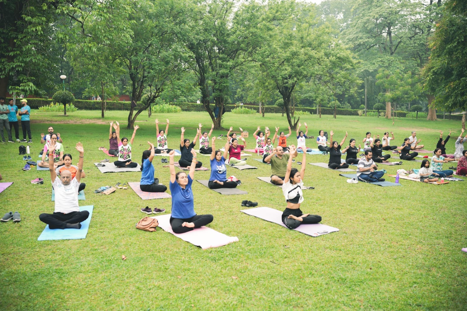 Serene wellness retreat setup with meditation cushions, aromatic candles, natural outdoor setting, people practicing mindfulness and relaxation